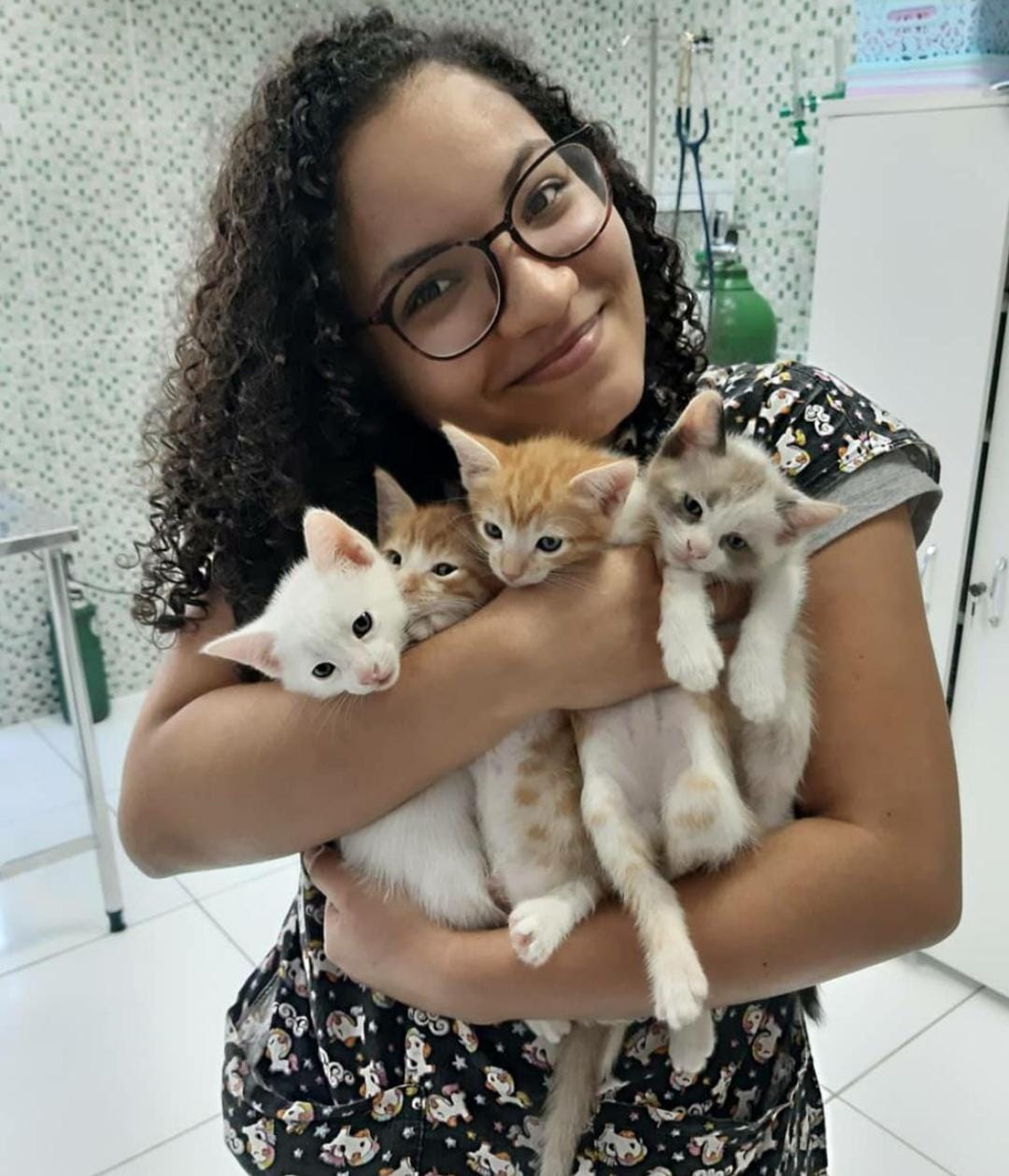 Dani abraçada com 3 gatinhos.